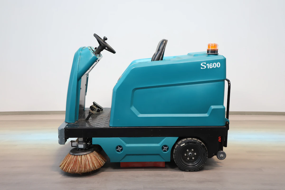 Ride-on commercial floor scrubber maintaining a large facility floor